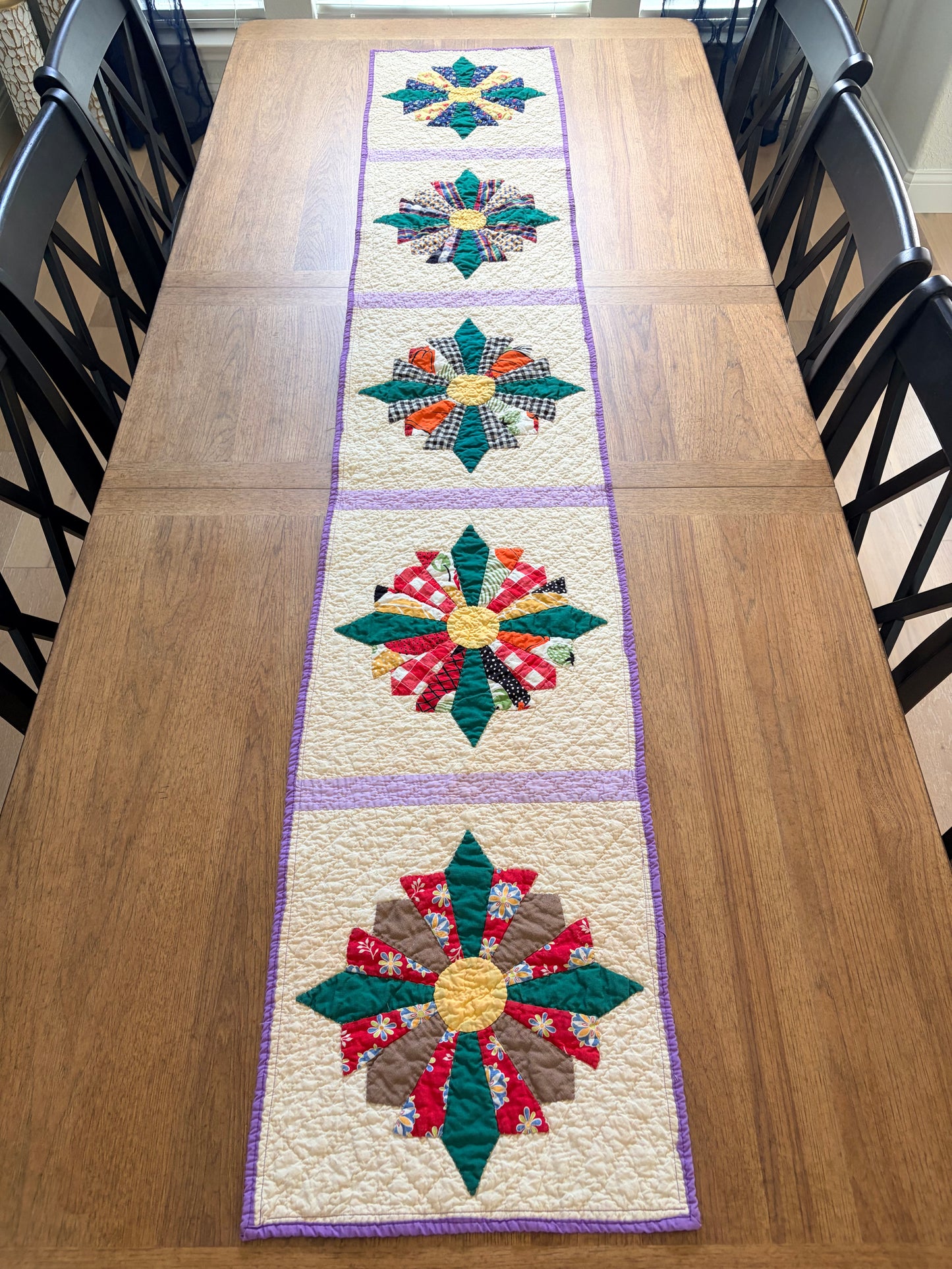Quilted table runner with floral patterns on a wooden table