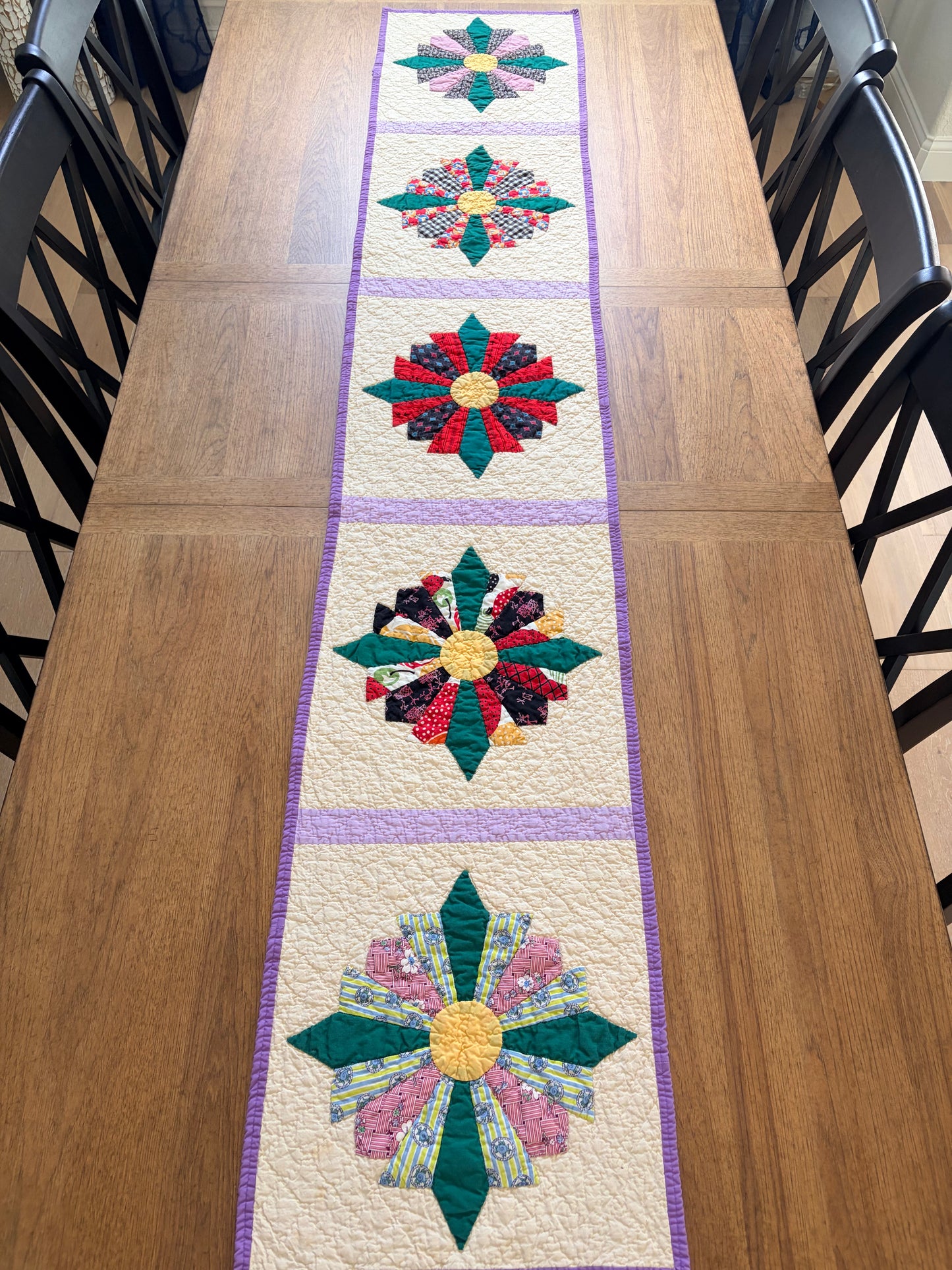 Quilted table runner with floral patterns on a wooden table
