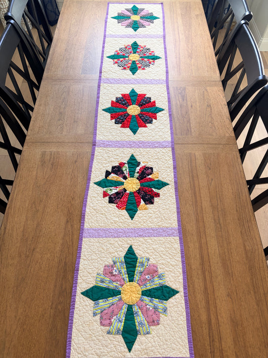 Quilted table runner with floral patterns on a wooden table