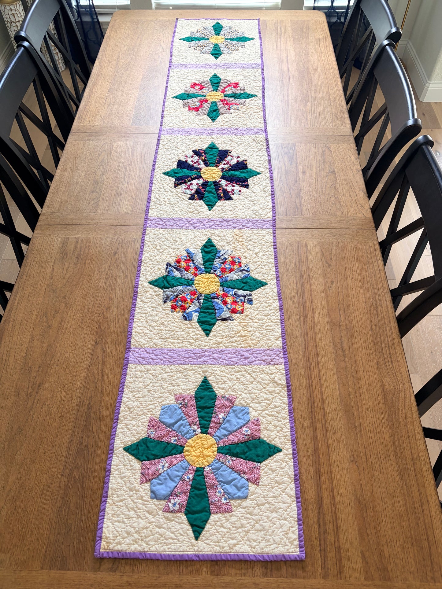 Quilted table runner with floral patterns on a wooden surface